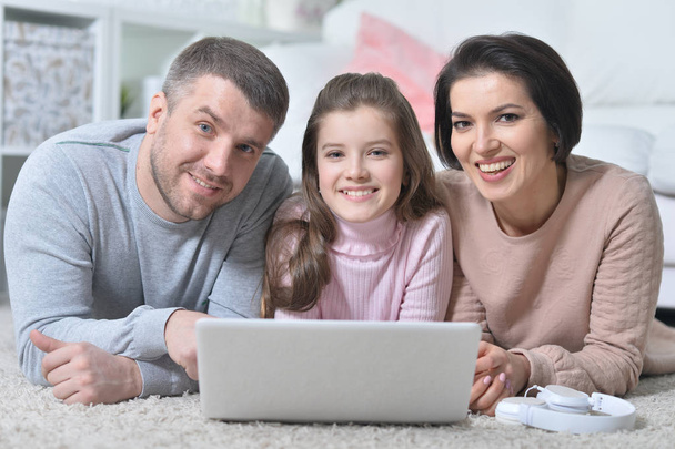 щаслива сім'я використовує ноутбук вдома
 - Фото, зображення