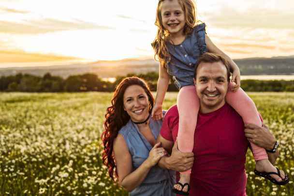 Aile açık havada vakit birlikte Baba, anne ve kızı günbatımı sırasında eğleniyor musun. - Fotoğraf, Görsel