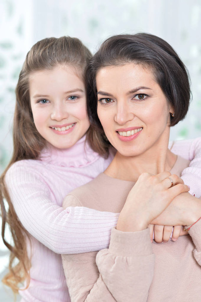 Close-up portrait of a charming girl with mom at home - Foto, Imagen
