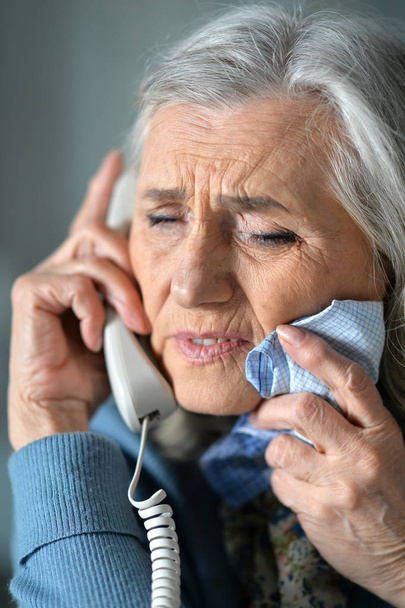 Portrait of upset senior woman calling doctor  - Foto, Imagen