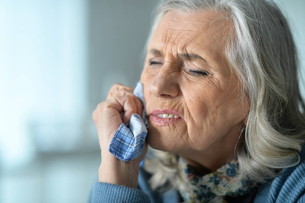 Close up portrait of sick senior woman with handkerchief - Fotó, kép