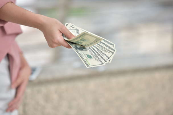 Женщина держит в руках долларовые банкноты.
 - Фото, изображение