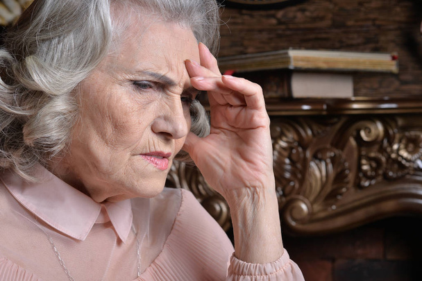 Közelkép egy szomorú, fejfájásos idős nőről - Fotó, kép