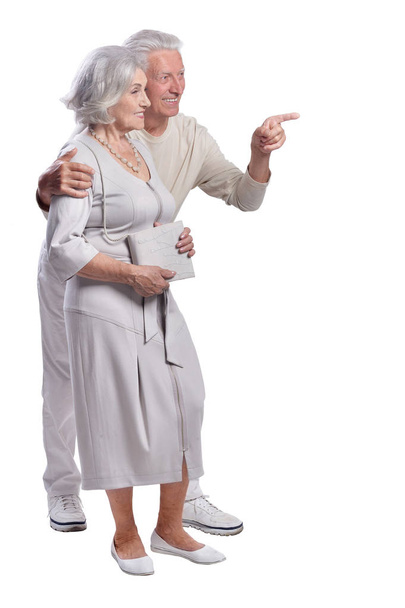 Portrait of happy senior couple pointing to the right on white background - Zdjęcie, obraz