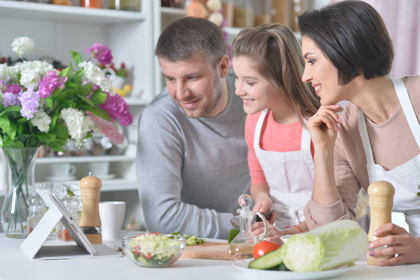 young family cooking together at kitchen - Foto, Bild