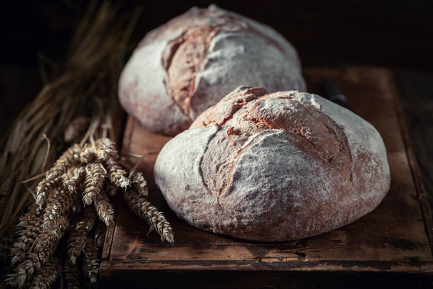 Homemade loaf of bread with grain and ears - Foto, afbeelding