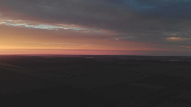 Panorama en movimiento horizontal jugosa puesta de sol de color brillante en los campos a una altitud de 500 metros sobre el suelo. Bajo perfil. Color épico. Vista aérea
 - Metraje, vídeo