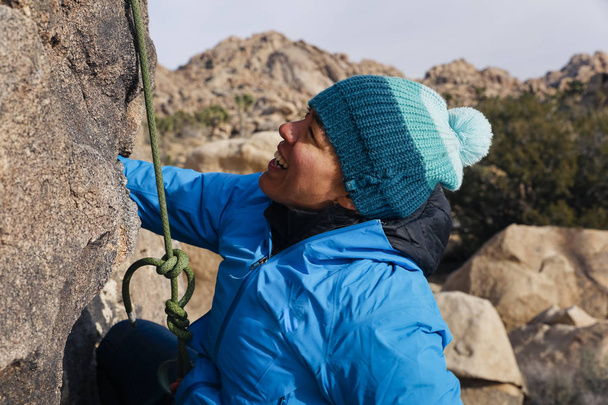 Sekarotuinen nainen kallio kiipeää aavikolla
 - Valokuva, kuva