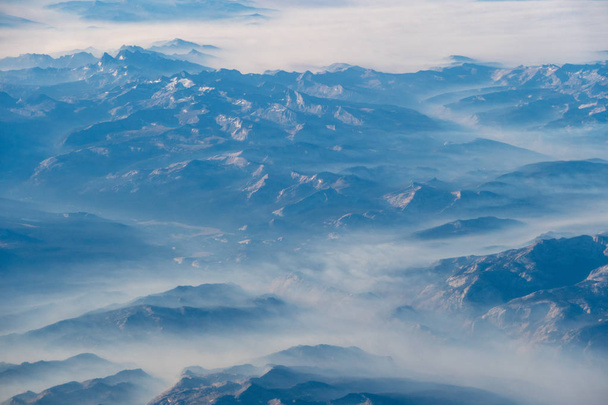 Vista aérea das montanhas da Serra Nevada cheias de fumaça de fogo. Califórnia ao nascer do sol tiro de um avião
 - Foto, Imagem