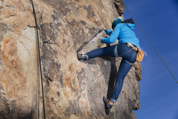 Mixed race female gay rock climber wearing cold weather gear climbing in Southern California - Photo, Image