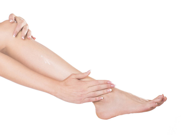 om toe te passen voet crème wordt verwijderd in studio isoleren op een witte achtergrond - Foto, afbeelding