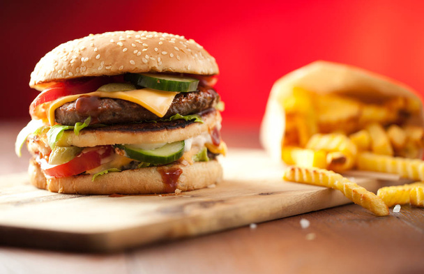 Fast food hamburger and french fries on a wooden Background - Photo, image