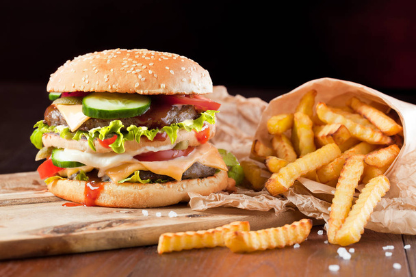 Fast food hamburger and french fries on a wooden Background - Foto, Bild