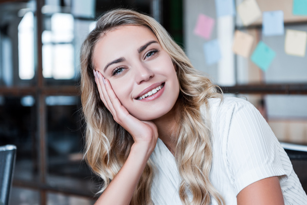 portrait of beautiful young blonde businesswoman smiling at camera in office - Foto, imagen