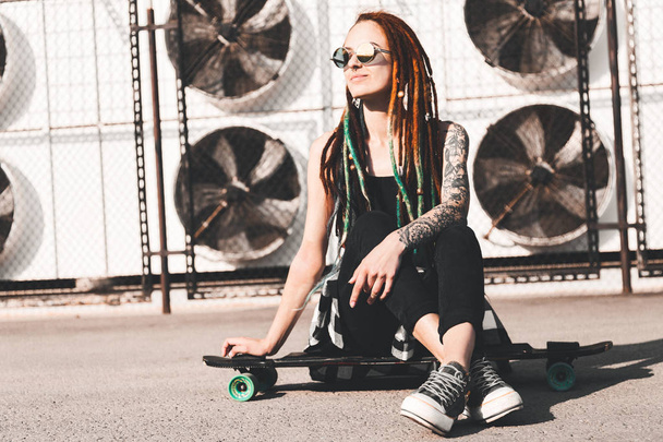 young girl with tattoo and dreadlocks on urban industrial background - Фото, зображення