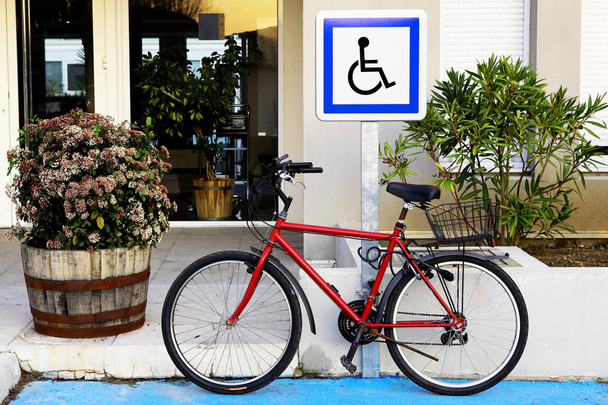 A bicycle in front of a sign. - 写真・画像