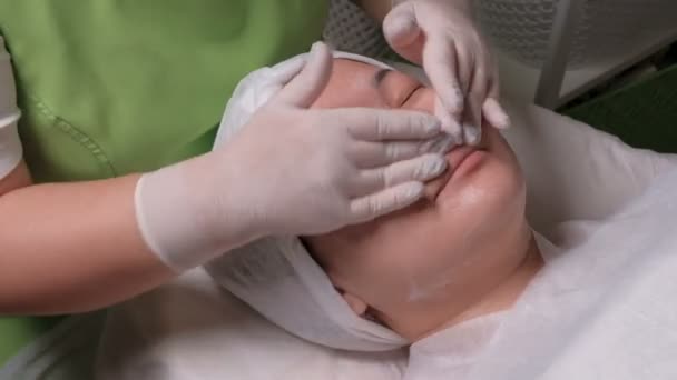 Muzułmanin dziewczyna na procedury do głębokiego oczyszczania skóry. Ręce kosmetyczki są mycia twarzy kobieta Azji. Zdrowia i estetyki wyglądu w salonie piękności. - Materiał filmowy, wideo