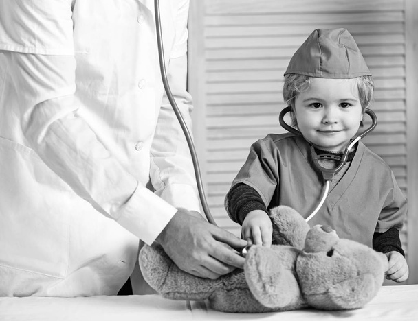 Health and childhood concept. Little assistant examines teddy bear. - Photo, image