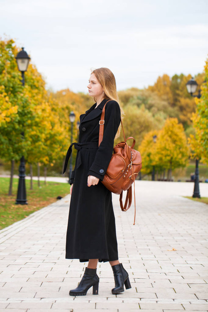 Mladá krásná blondýnka v černém kabátě, chůze na podzim park - Fotografie, Obrázek