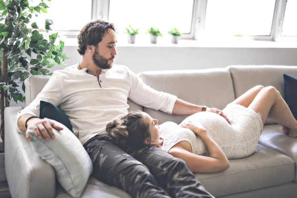 Young happy Couple expecting baby on sofa - Foto, Imagen