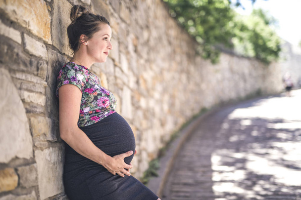 Portrait of a happy and proud pregnant woman on urban background - Zdjęcie, obraz