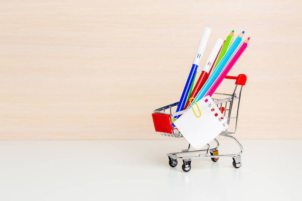 Stationery items in shopping trolley at left side - Foto, Imagem