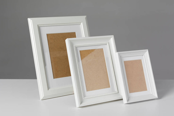 Different empty photo frames on table - Φωτογραφία, εικόνα