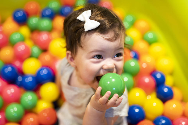 Portrait of a adorable infant on colorful balls - Fotó, kép