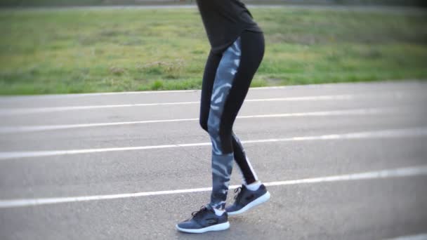Спортивная девушка делает упражнения на ногах на открытом стадионе
 - Кадры, видео