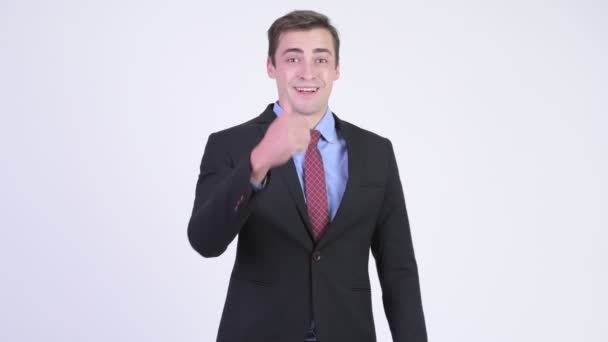 Young happy handsome businessman giving thumbs up - Video, Çekim