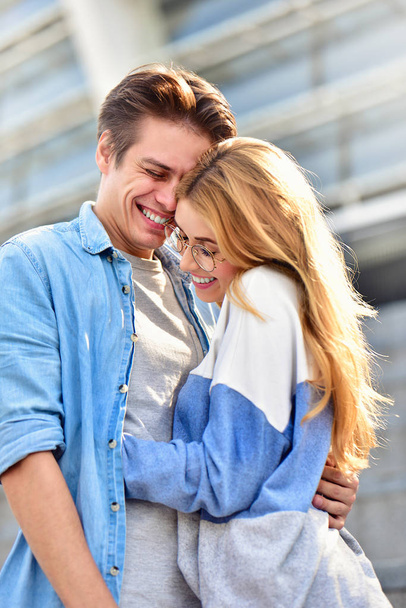 Beautiful couple in love dating outdoors and smiling. Beautiful girl embraces the guy - 写真・画像