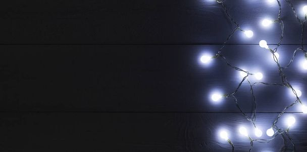 Christmas light on wooden background top view - Valokuva, kuva