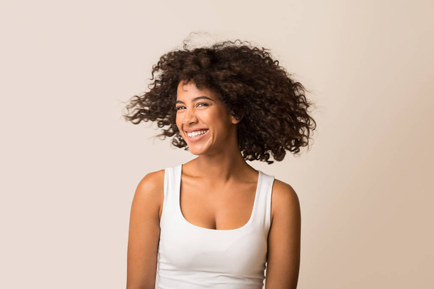 Африкано-американская женщина дурачится со своими вьющимися волосами
 - Фото, изображение