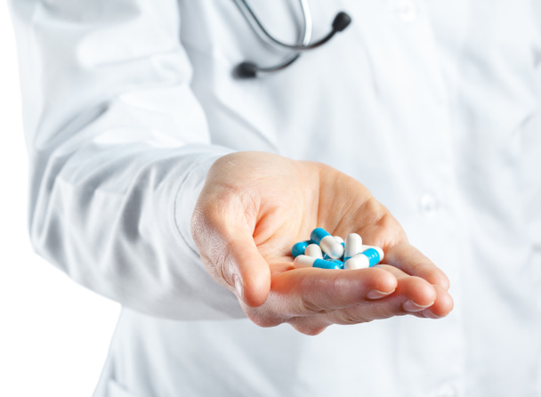 Female doctor holding a pills. Isolated on white. - 写真・画像