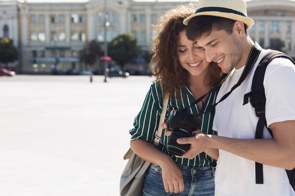 Tourist couple looking at photos on camera - Photo, Image