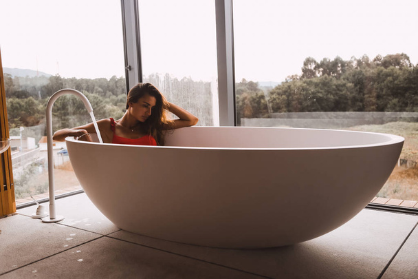 Frau beim Baden und Entspannen in einer modernen Badewanne - Foto, Bild
