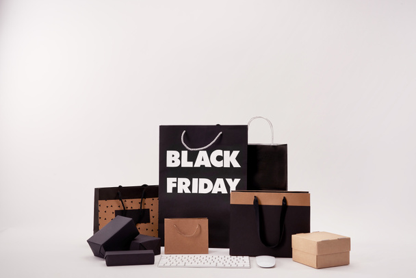 computer keyboard with mouse and various boxes with shopping bags with black friday sign on white - Photo, Image