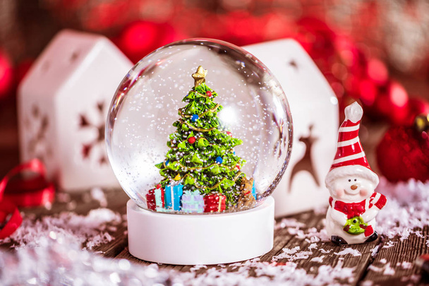 Christmas snow globe on wooden background - Foto, afbeelding