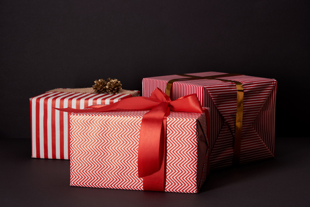 wrapped gift boxes lying on black surface, black friday concept - Photo, Image