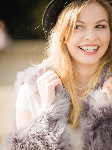 Beautiful young blonde woman wearing fedora hat, long warm fur sweater jumper outdoor - Valokuva, kuva