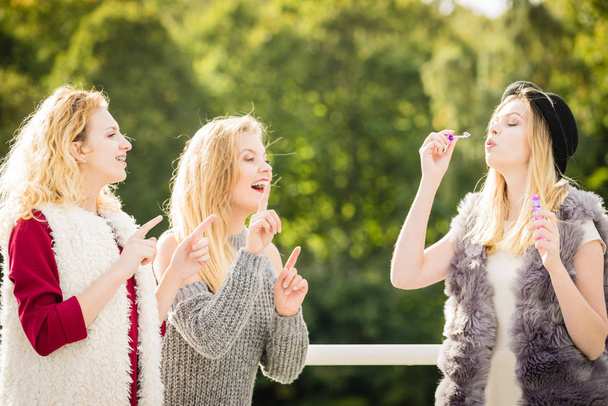 Vacations joy, friendship concept. Women friends having fun blowing soap bubbles outdoor. - Fotografie, Obrázek