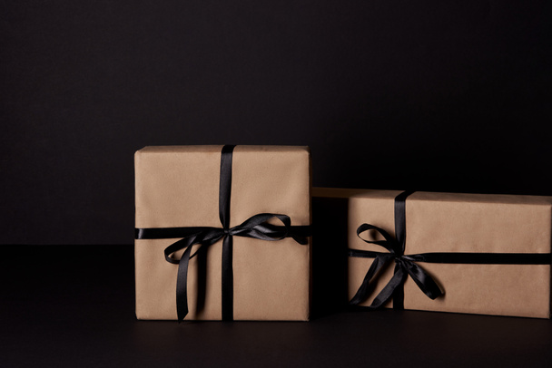 wrapped gift boxes on black surface, black friday concept - Foto, imagen
