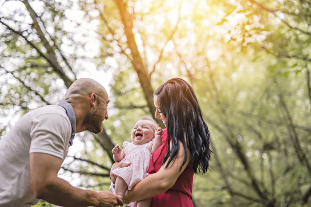 Father Mother and daughter baby in summer meadow park - Foto, imagen