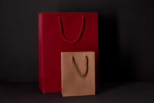 paper bags on black surface, black friday concept - Foto, Imagem