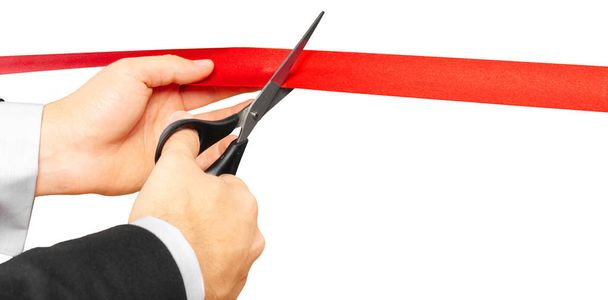businessman with Scissors cutting red ribbon or tape. Isolated on white background. - Фото, изображение