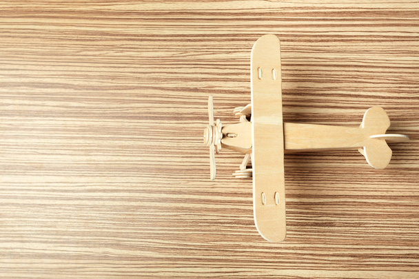  крупним планом дерев'яний іграшковий літак на столі
 - Фото, зображення