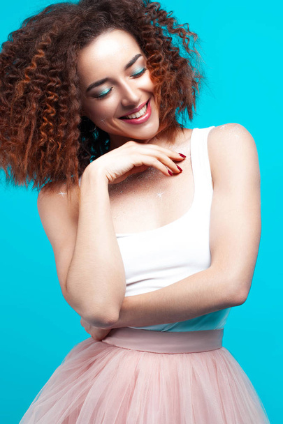 Beautiful smiling young woman on blue background. Holiday and emotions concept - Foto, immagini