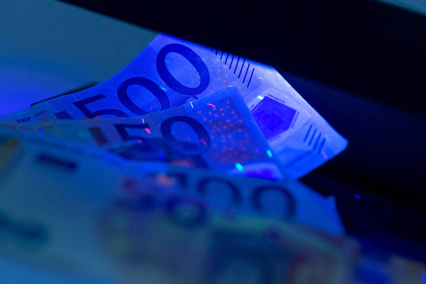 Close-up van het controleren van geld onder de UV-lamp - Foto, afbeelding