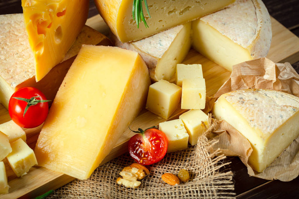close up of different types of cheese on wooden table - Fotoğraf, Görsel