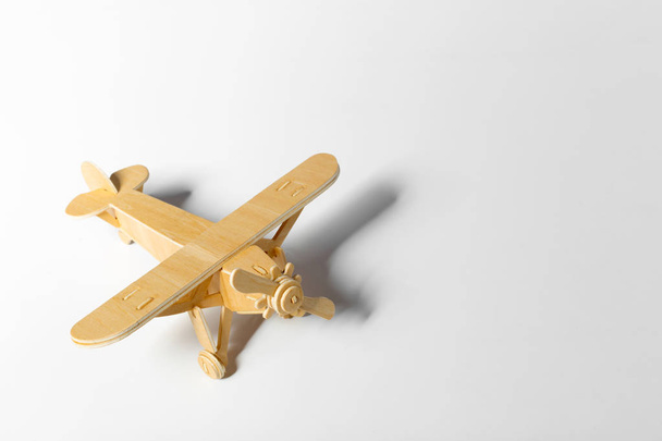 close up of wooden toy airplane isolated on light background  - 写真・画像